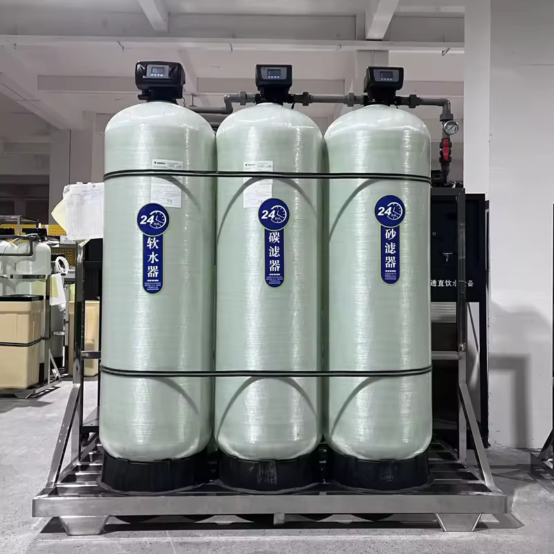 An industrial water treatment system featuring three large green cylindrical filter tanks and control panels, suitable for large-scale water purification needs.